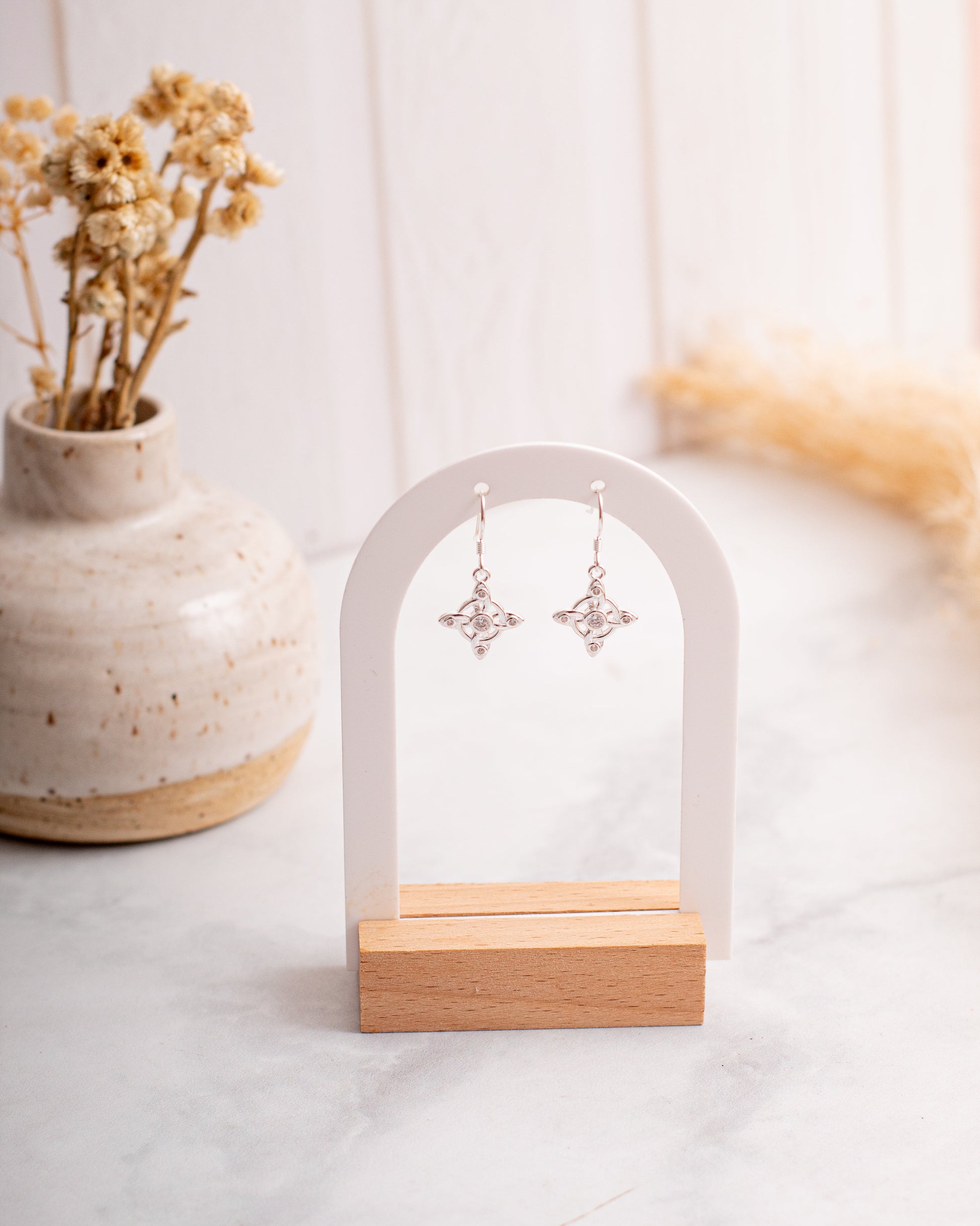 Aros de Plata colgantes para mujer con simbolo nudo de bruja y circonitas. Joyería en Santiago.